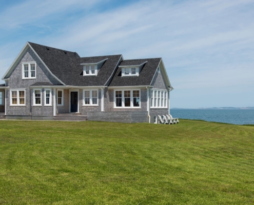 A seaside house with a lush green yard.