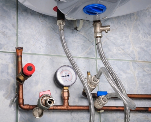 Pipes leading into a hot water heater.