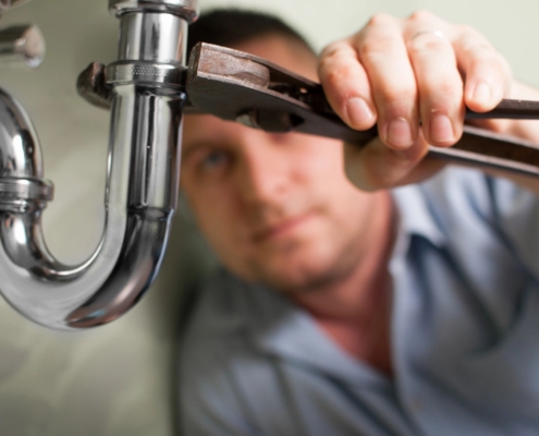 A plumber working on a pipe.