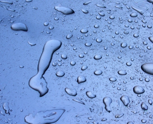 An image of water droplets on a flat surface.
