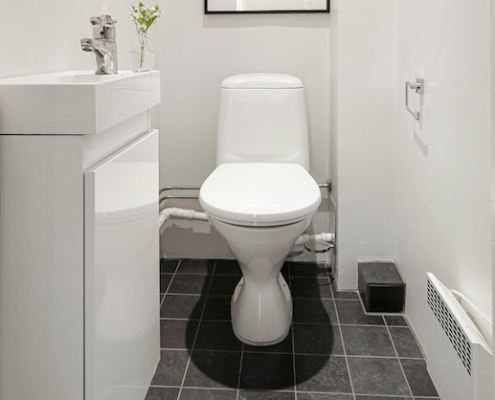 Image of a toilet in a white bathroom.