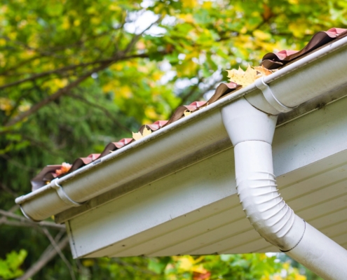 Gutter and Downspout Cleaning A gutter filled with leaves.
